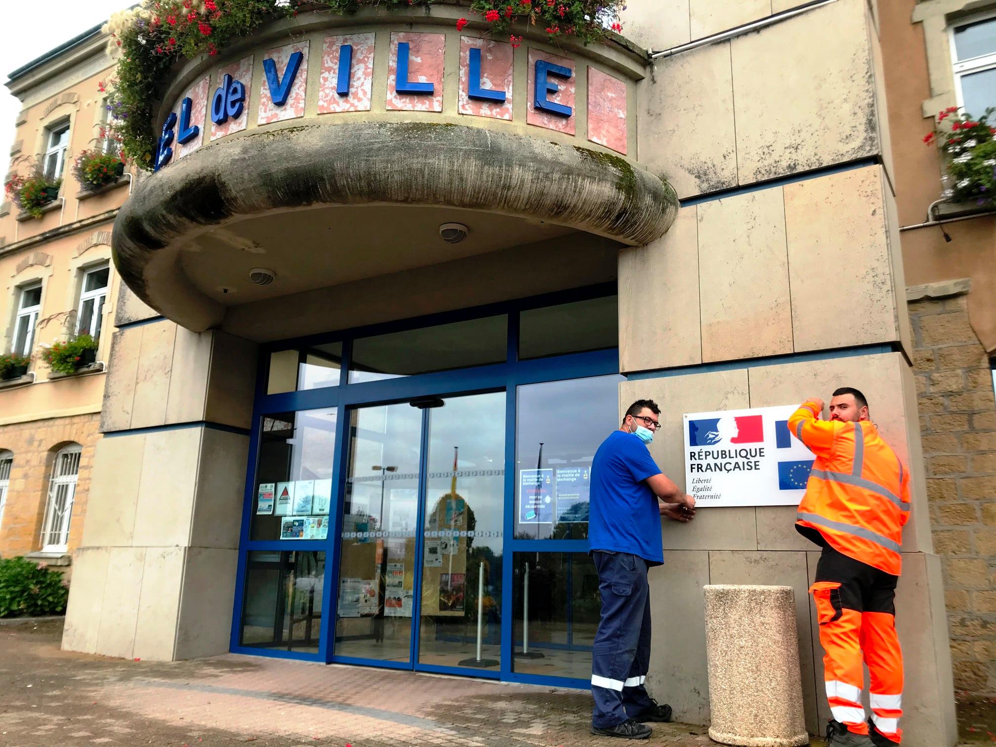 Installation de la devise de la nation sur le mur de la mairie